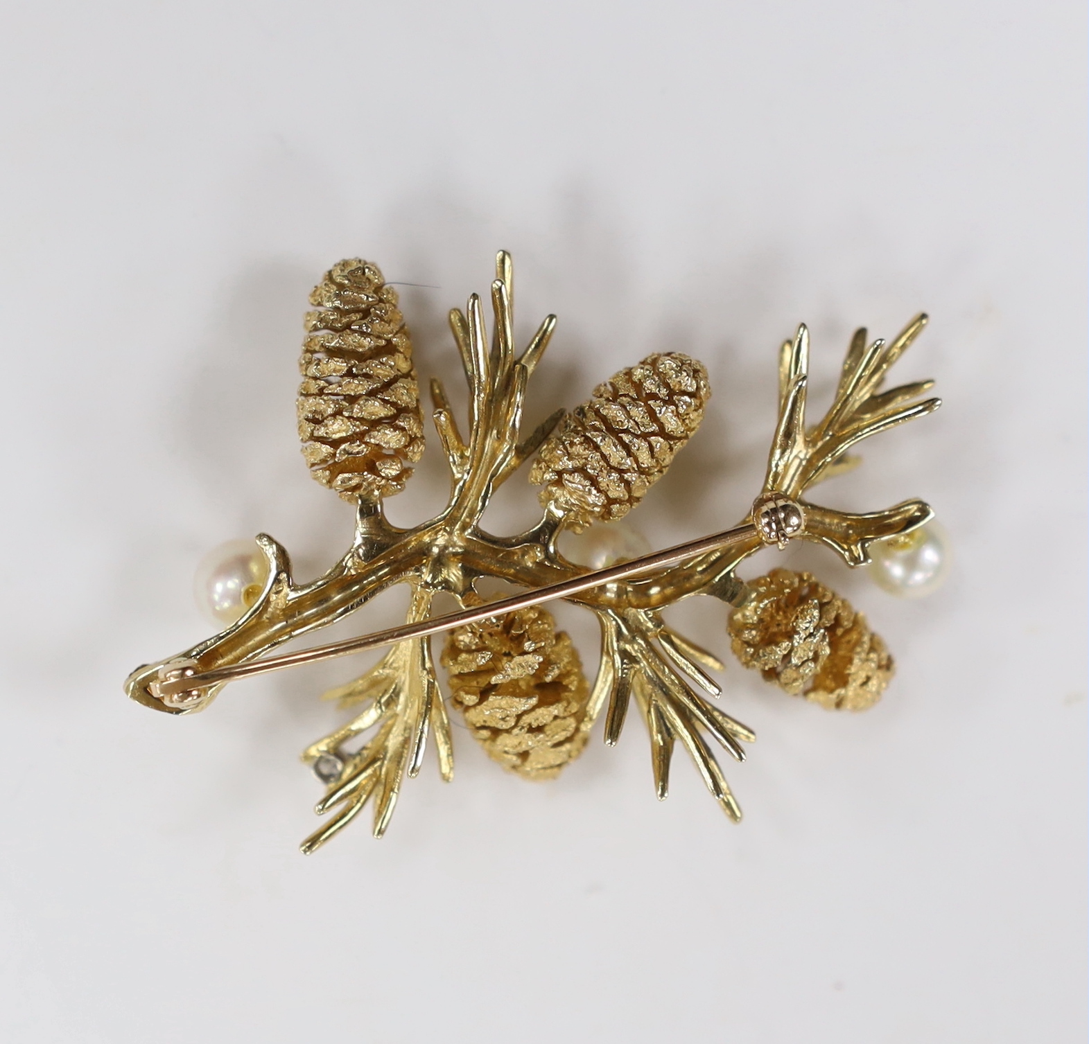 An American yellow metal, four stone diamond and three stone culture pearl set 'pine tree sprig' brooch, 56mm, gross weight 21.9 grams.